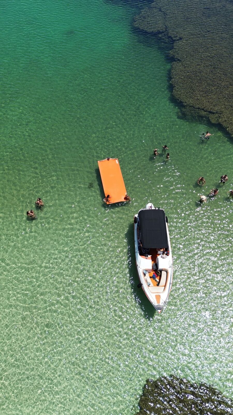 Vista aérea da lancha da Alma de Praia em piscinas naturais de água turquesa