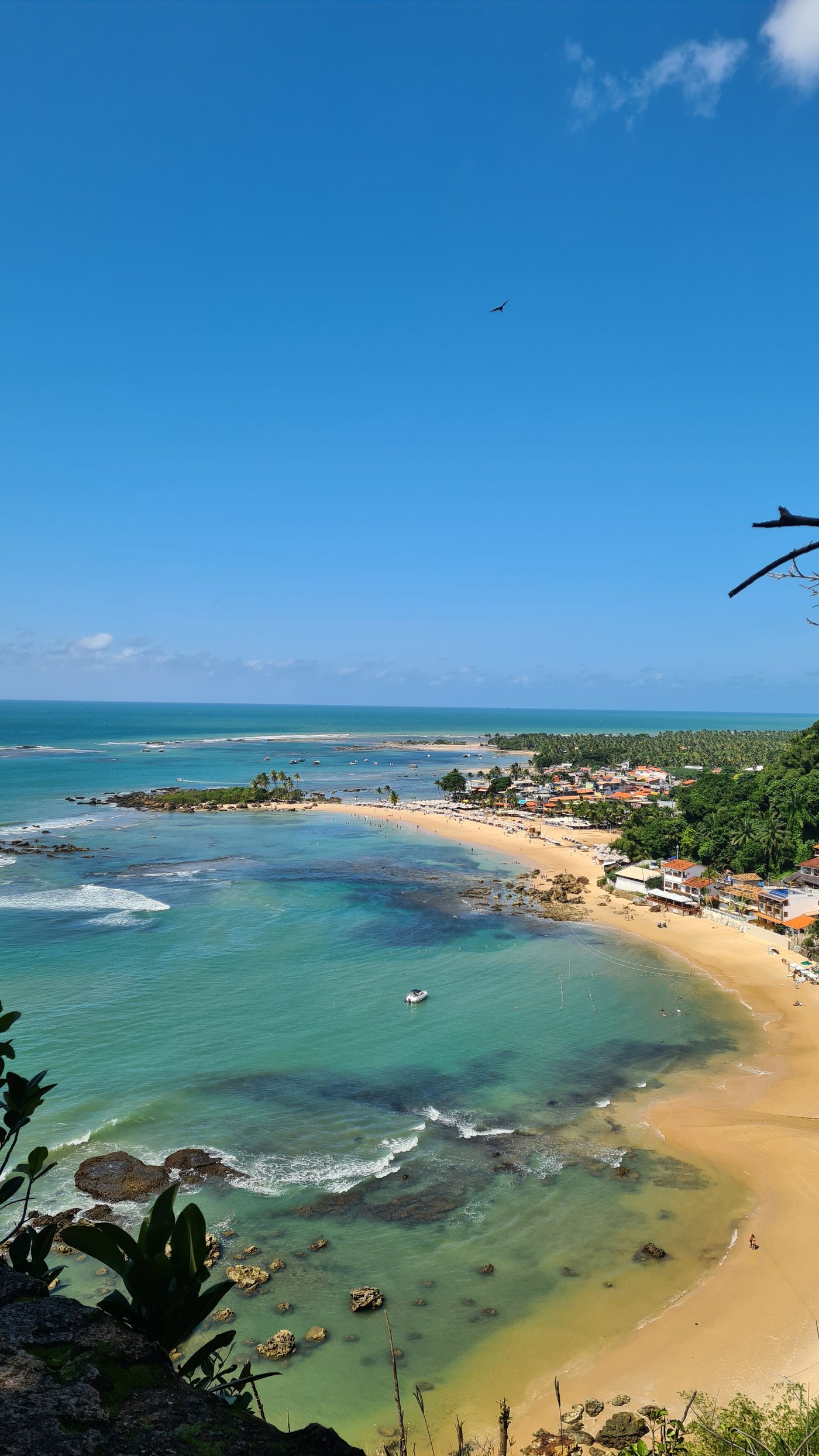 Praia da vila de Morro de São Paulo com barracas e guarda-sóis, destino de quem paga a taxa TUPA na chegada